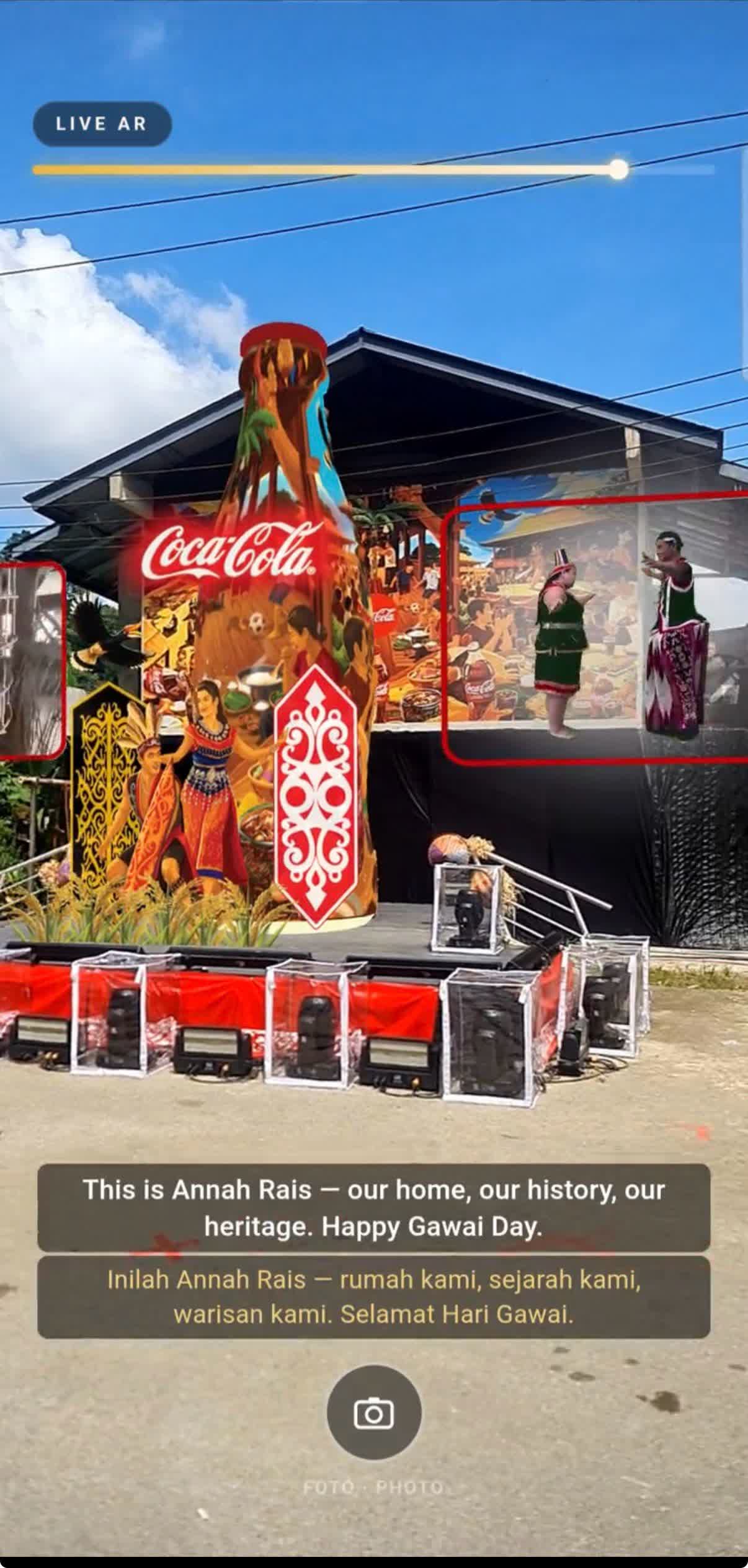 Live WebAR view of the Monument of Cokennection at Kampung Annah Rais, showing animated Bidayuh dancers overlaid on the longhouse